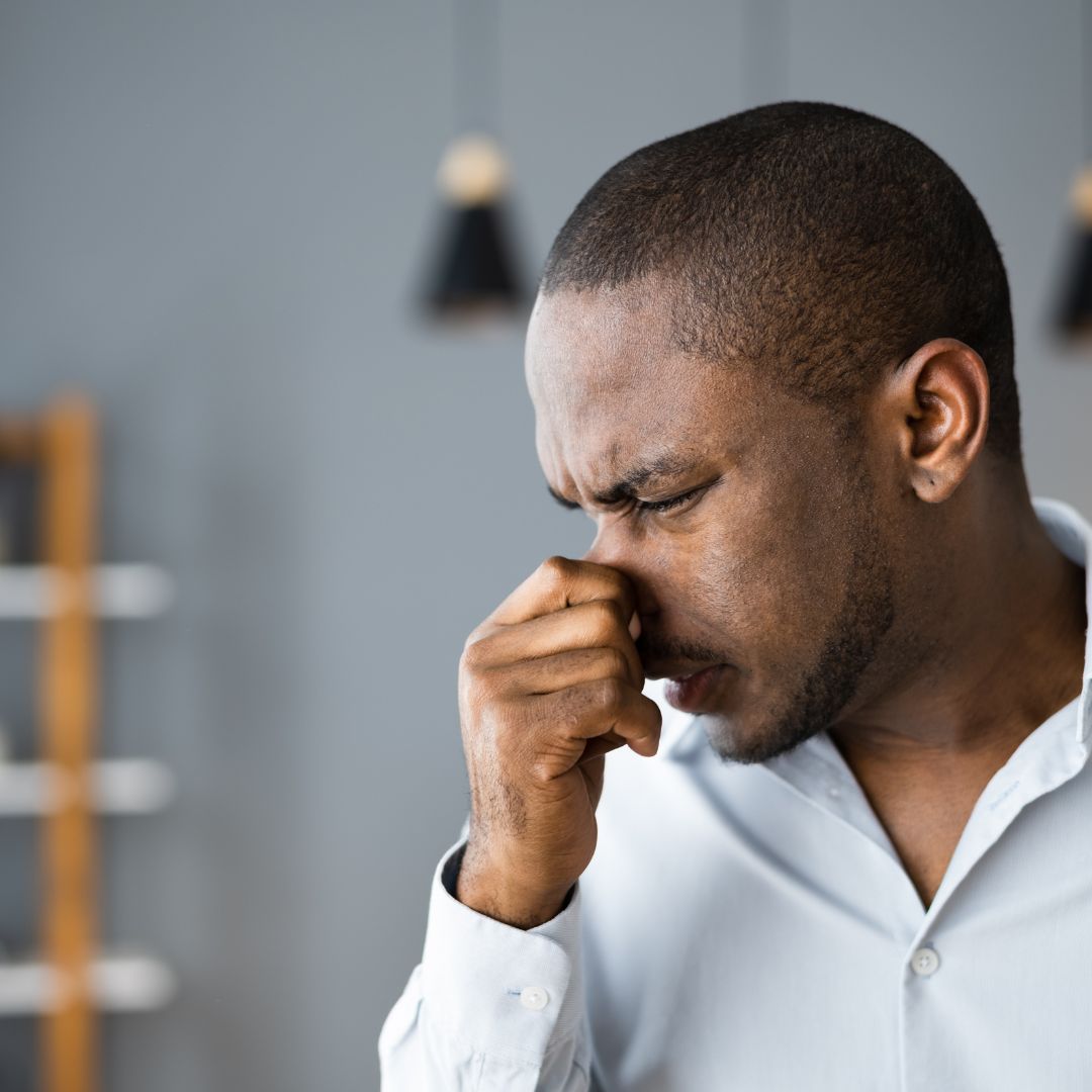 person holding their nose because of a bad smell