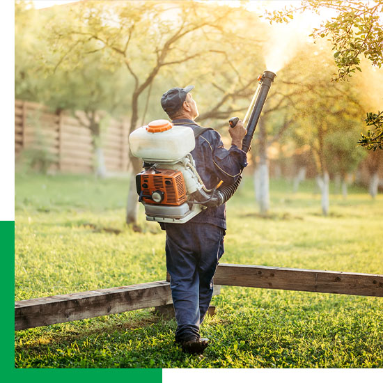pest control worker spraying outside for pests