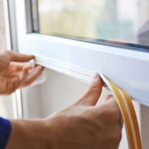 person sealing a window