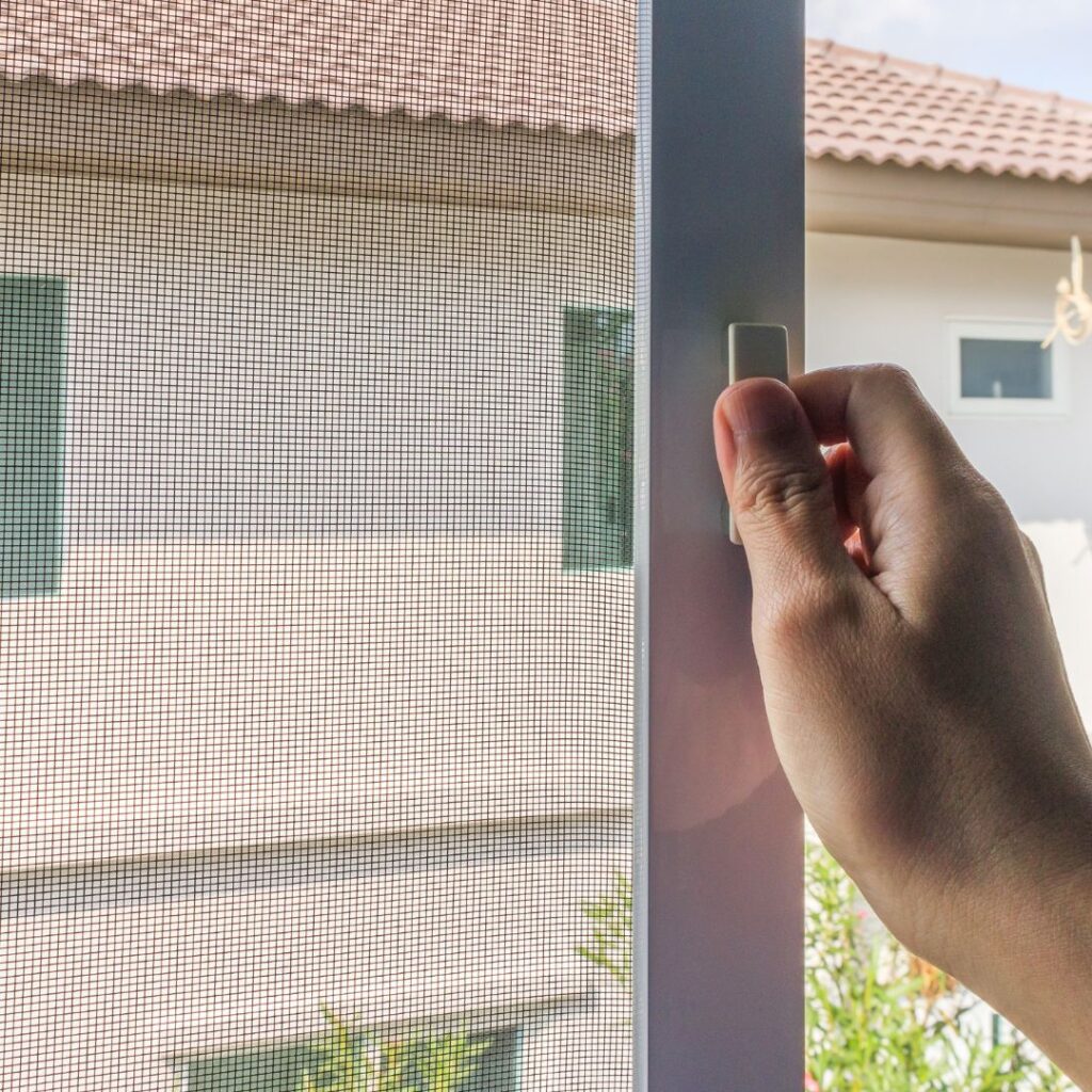 person closing window screen