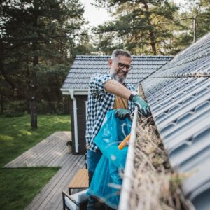 person cleaning his gutters