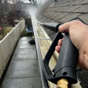 a person power washing a gutter